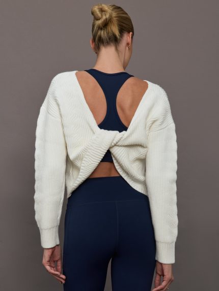Model wearing Ivory pullover sweater with a twist in the back.
