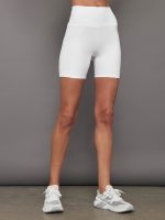 Model wears fitted white biker shorts with a high-rise waistband and a 6-inch inseam.