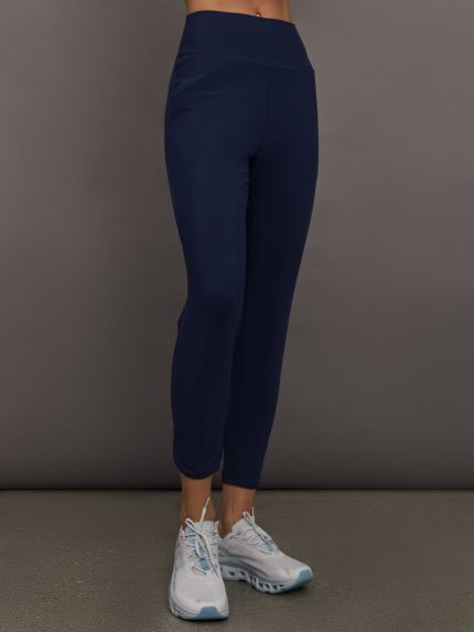 Model wears navy high-rise joggers with a slim, relaxed fit and a slightly cropped tulip-shaped hem and a wide waistband.