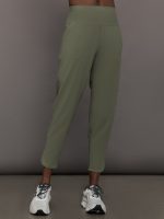 Model wears a pair of army green colored joggers with a thick waistband perfect for everyday activities.