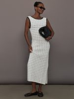 Model wearing a long ivory crochet dress with black accents