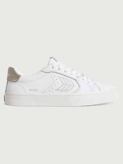 White sneaker with metallic gold heel and leaf logo on side.