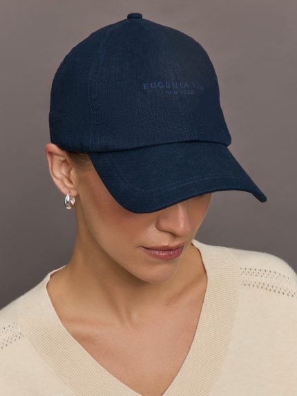Model wears a navy baseball cap with Eugenia Kim words across the front.