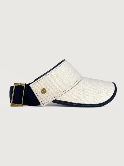 White linen visor with navy edging around front and top, black strap and gold hardware.