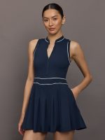 Model wears a navy sleeveless activewear dress with white piping.