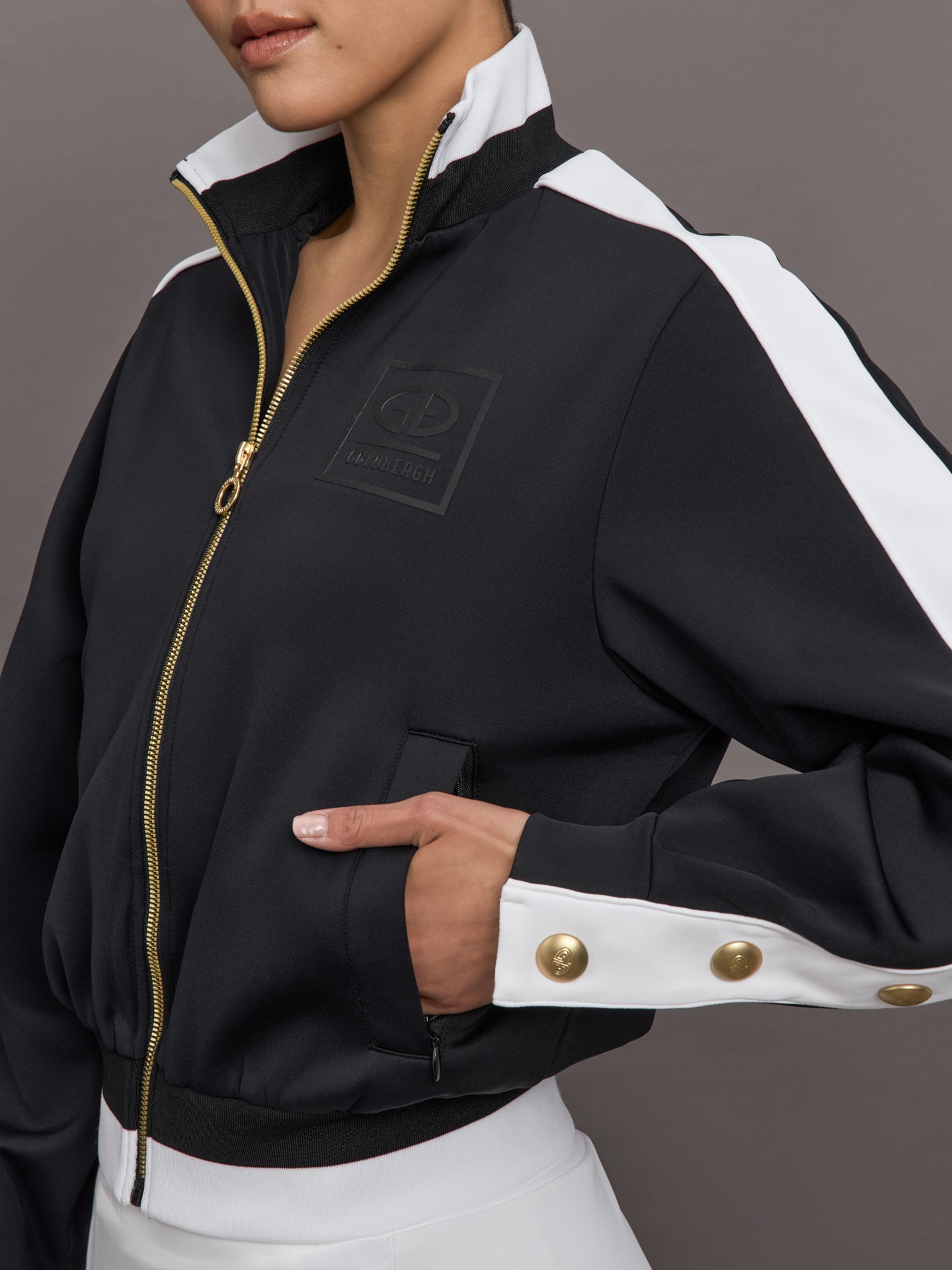 GOLD-GB378-41-251-BLKBLK-Monaco-color-Black_9169-Edit Model wears A black track jacket with white side paneling and gold zippers and snaps along forearm.