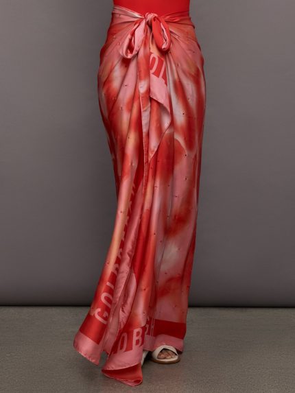 Model wears a multicolored red silky long skirt that ties at the waist.