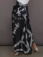 Model wears a black and white printed long silky skirt tied at waist.