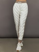 White quilted jogger pants with brown accents on a gray background