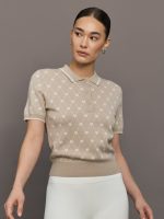 Woman wearing a beige patterned shirt against a brown background