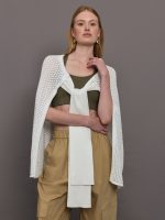 Model wears a sheer mesh white over the shoulder cape tied together at the front by sleeves.