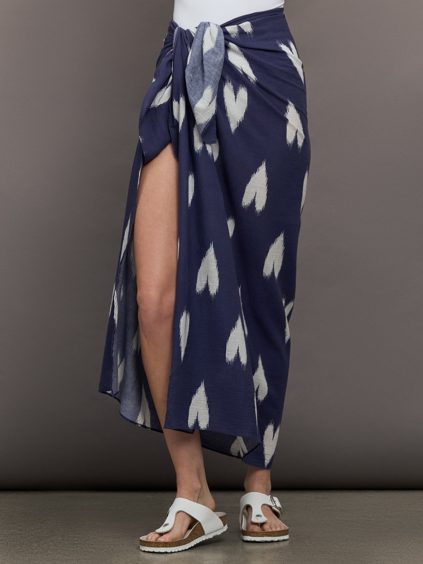 KRRNL-KR25-0541-BLUEBLUDRK-Roper-Ikat-Hear-Sarong-color-Indigo_31534-Edit Model wears Indigo-colored sarong featuring a white heart pattern.