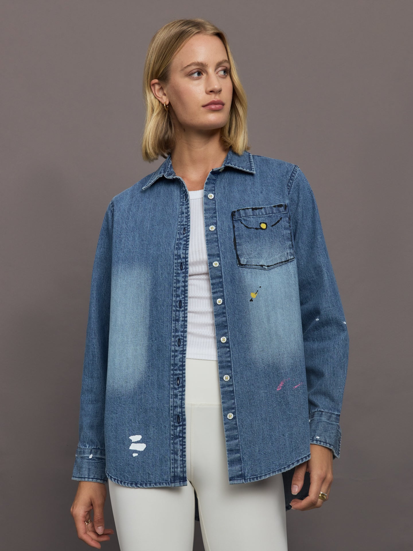 KRRNL-KR253-2185-BLUEBLUDRK-Mia-Studio-Shirt-color-True-Denim_12172-Edit Woman wearing a blue denim jacket over a white outfit on a gray background