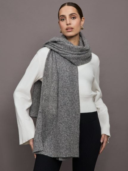 Model wears an oversized heathered grey colored scarf around her neck.