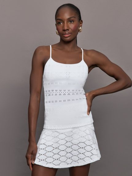 Model wears a lightweight white tank with sheer patterned detailing perfect for tennis.