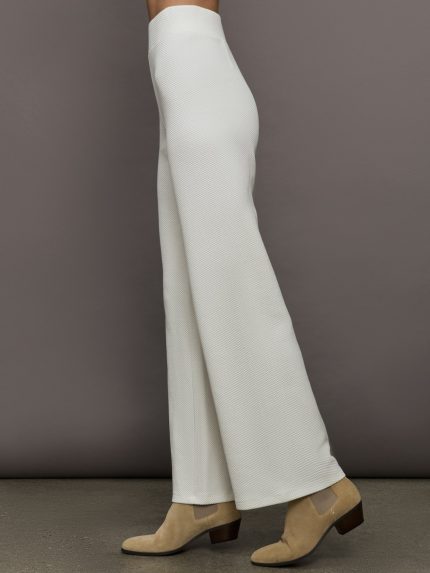Model wears a pair of high waisted white knit wide leg pants.