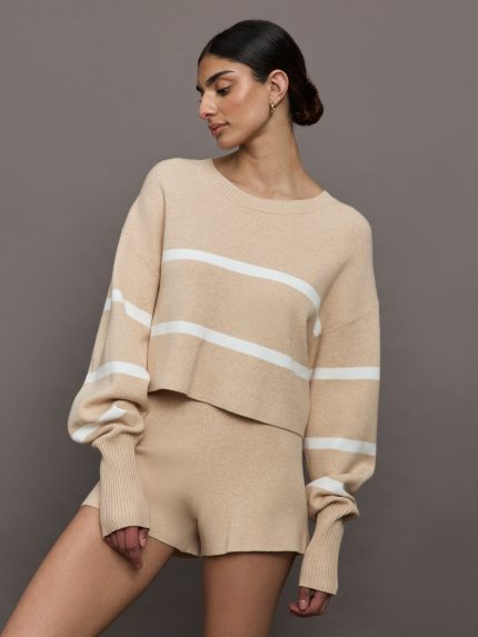 Model wears a boat neck oversized cropped khaki sweater with white horizontal stripes.