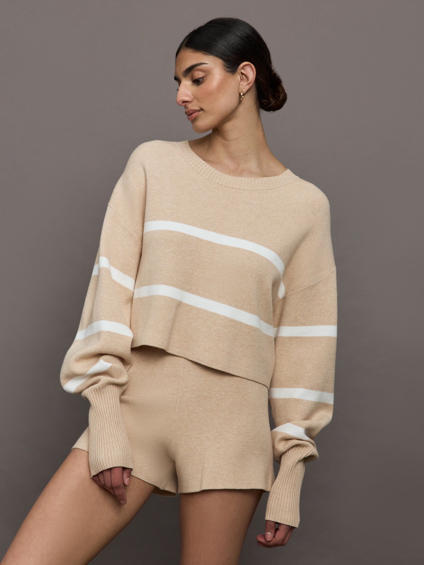 LUNE-LA1467-NUDEOFFWHI-Olly-Cropped-Stripped-Sweater-color-Beige-Melange_6400-Edit Model wears a boat neck oversized cropped khaki sweater with white horizontal stripes.