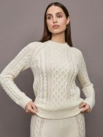 Model wearing a cream colored vertically textured wide cable knit sweater.