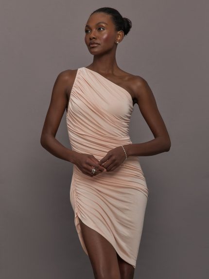 Model wears the Diana Mini Dress in Baby Pink, featuring a sleeveless, asymmetrical design with a fitted bodice