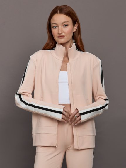 Model wears baby pink jacket with a turtleneck, front zipper, and side stripes on the sleeves.     