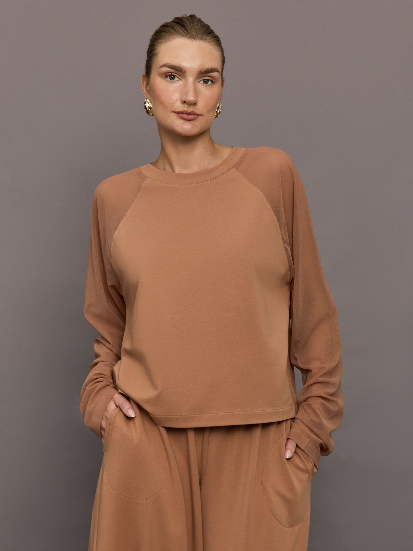 NORMA-ST1256TMP08833-BRWNBRWLT-Oversized-Raglan-Sleeve-Top-W-Mesh-color-Cappuccino_24874-Edit Model wears a light brown long sleeved baseball style loungewear top.