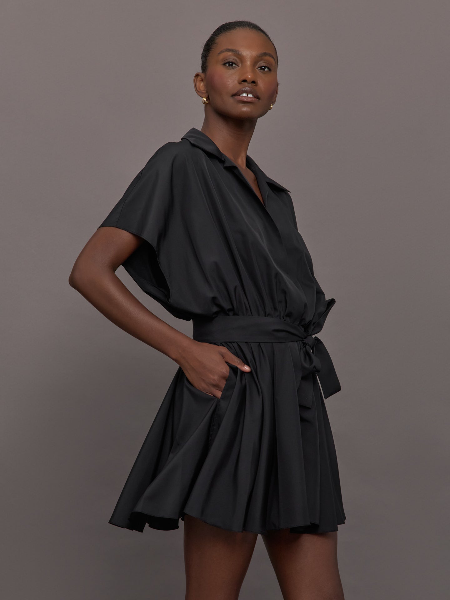 NORMA-ST2253PHE88001-BLKBLK-Super-OS-Sleeveless-BF-NK-Shirt-Flared-Mini-Dress-color-Black_27668-Edit Model wears the Super OS Sleeveless BF NK Shirt Flared Mini Dress in Black with a flared skirt, belted waist and collared neckline.