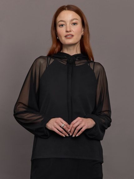 Model wears oversized black hooded top with mesh panel detailing.
