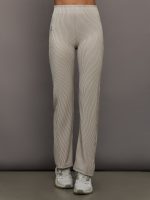 Model wears a pair of high waisted straight leg neutral pinstripe pants.