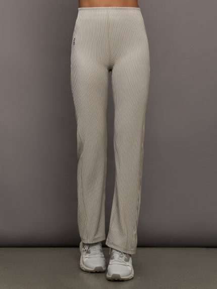 Model wears a pair of high waisted straight leg neutral pinstripe pants.