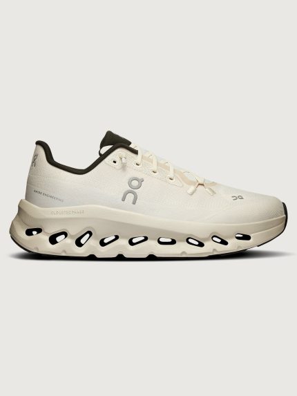 White sneakers with a unique sole design featuring circular cutouts beneath the heel area.