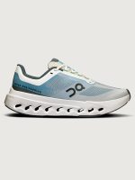 White athletic sneakers with blue accents and a distinctive design on the upper part.