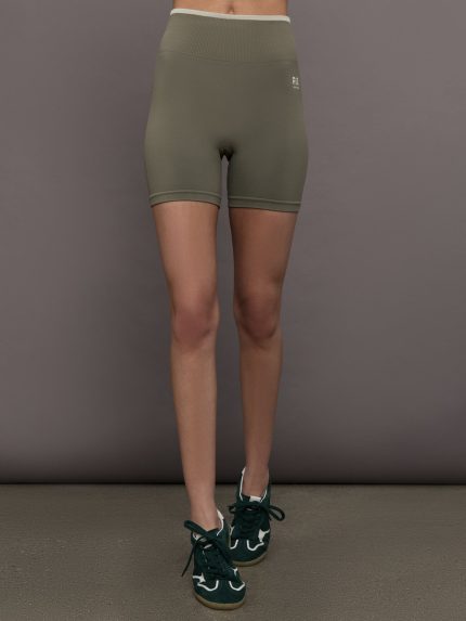Model wears a pair of high waisted olive/khaki biker shorts. 