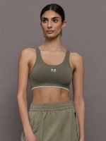 Model wears an olive/khaki scoopneck sports bra.