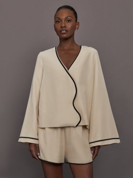 Model wearing a beige long sleeve shirt.