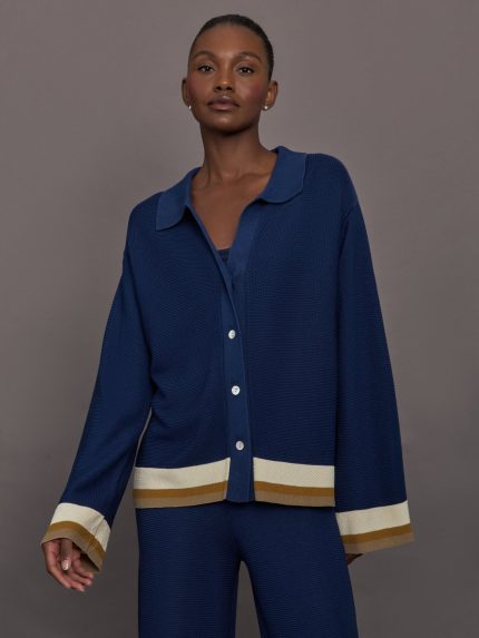 Model wearing a blue long sleeve top with white and beige accents.