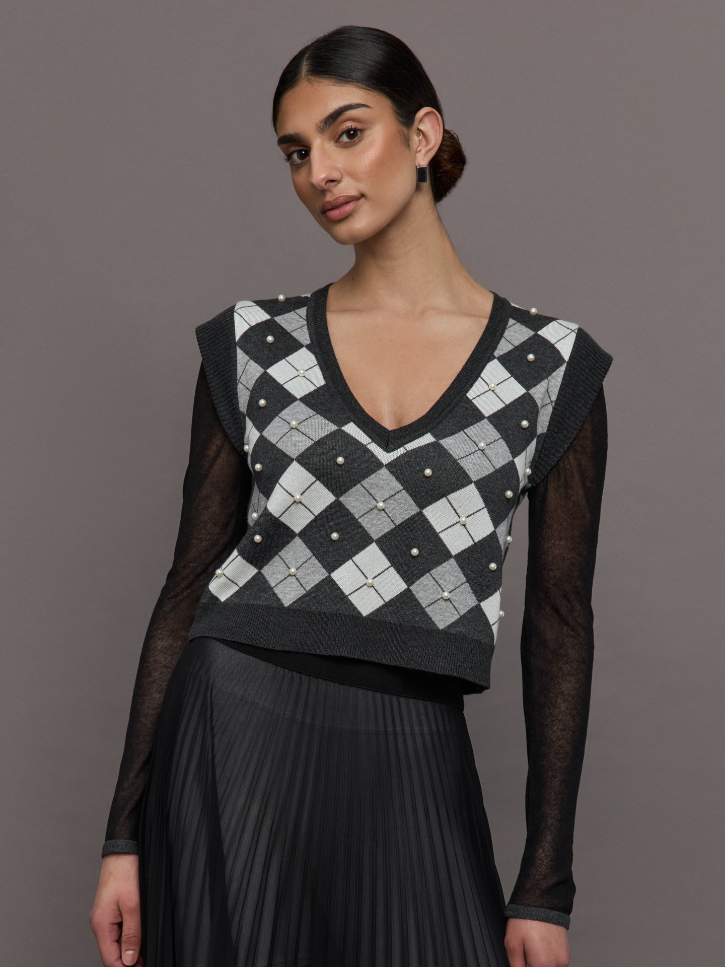 THEO-T2512K651-GREYSILV-Nomai-Plaid-Pearly-Vneck-Sweater-color-Grey-Silver_5854-Edit Model wears a gray argyle short sleeved V neck sweater with long black sheer sleeves.