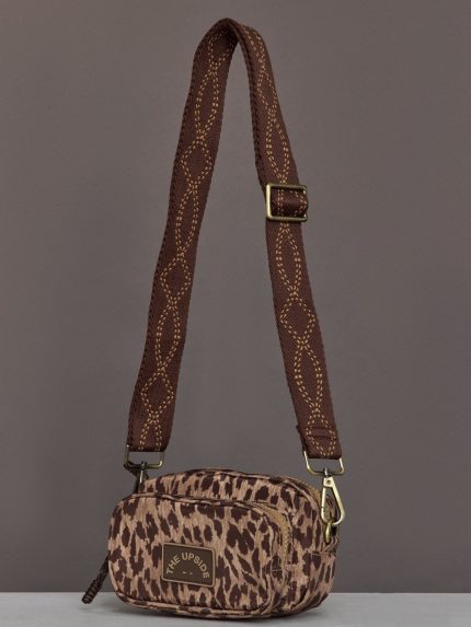 Crossbody bag with an animal print design, structured shape, adjustable strap, and zippered closure.