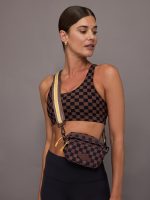 Model wearing brown and black checkered crossbody bag.