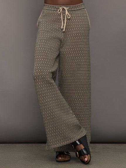 Model is wearing neutral patterned wide leg sweatpants with drawstring.