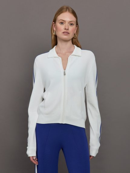 Model wears a white track jacket with blue racing stripes down the sides of arms.