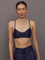 Model wearing a navy blue sports bra with a subtle pattern.