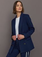 Model wears classic navy double-breasted blazer featuring structured shoulders and leopard detailing inside.