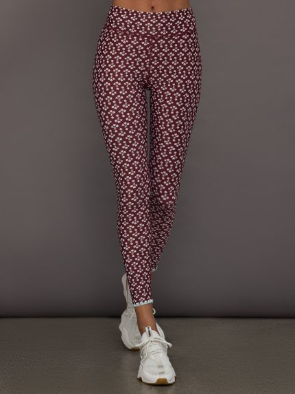 Model wears a high rise pair of red floral leggings.