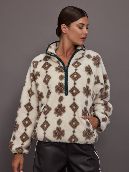 Woman wearing a patterned fleece jacket against a gray background