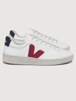White sneakers with red and blue accents, featuring a lace-up closure and the brand Veja visible on the side.