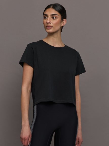 Model wears a cropped black crewneck tee shirt.