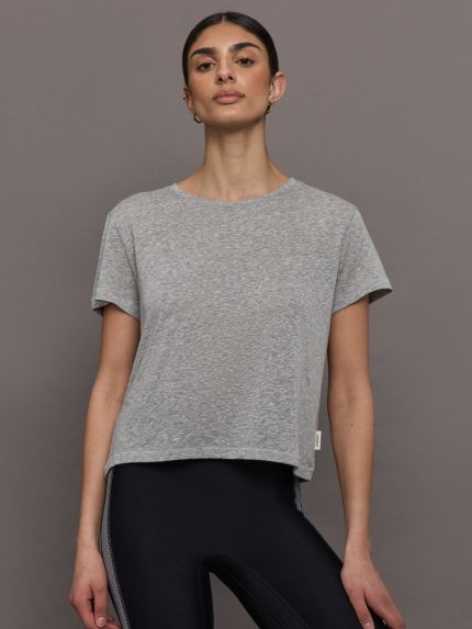 Model wears a heather gray crewneck short sleeved tee shirt.