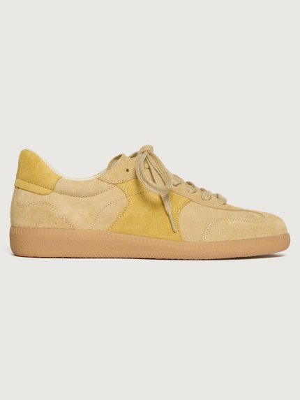 Tan suede low top sneaker with muted yellow detailing.